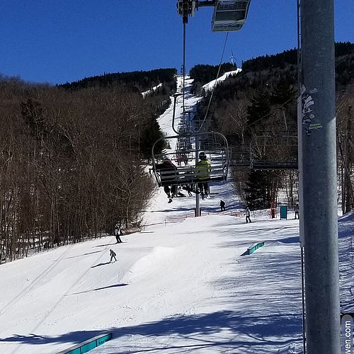 Photo taken while riding quad chairlift and looking down at skiers below