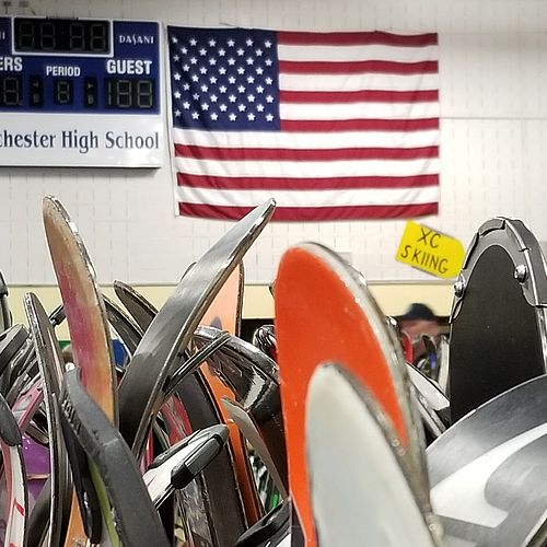 Skis stand on a rack in a school gym