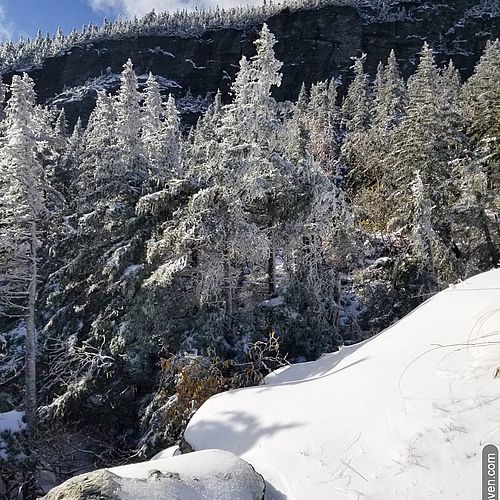 Snowy rocks, trees and cliff at the top of the gondola on Mt. Mansfield